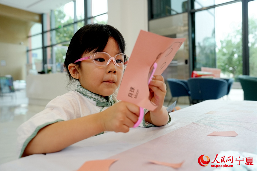 7月23日，寧夏銀川市居安家園社區“暑托班”里，一名小朋友正在剪紙。人民網記者 閻夢婕攝